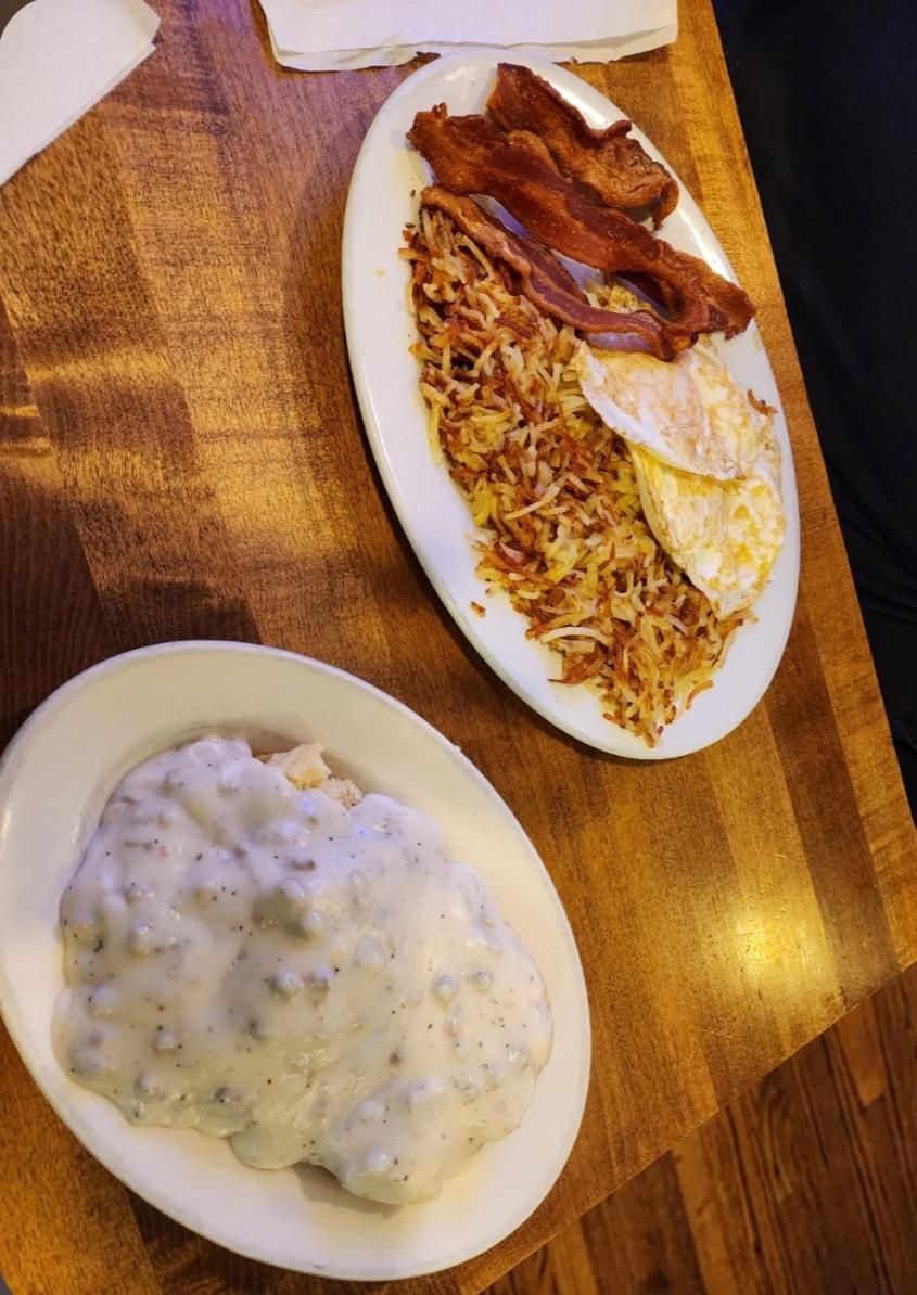 Biscuits under sausage gravy, with bacon, hash browns and fried eggs